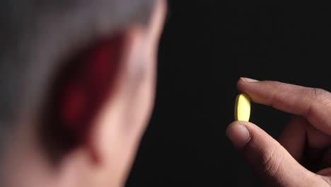 person holding a yellow pill