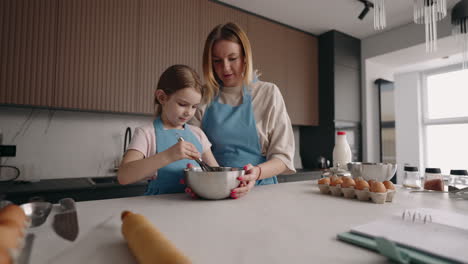 cooking masterclass for children adult woman and little girl are mixing ingredients in metal bowl