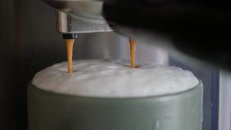 coffee being dispensed into a mug with frothed milk from an espresso machine