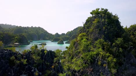 blue arrival pier on the lagoon of piaynemo islands in raja ampat indonesia, aerial flyover shot