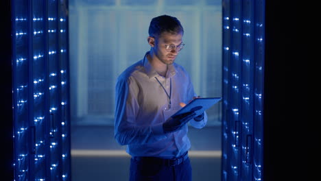 Male-Server-Engineer-in-Data-Center.-IT-engineer-inspecting-a-secure-server-cabinet-using-modern-technology-laptop-coworking-in-data-center.