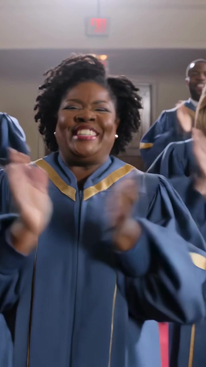 Vertical video: Smiling choir singer clapping and singing as music starts in church, in blue robe