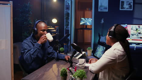 presenter having live conversation with man, enjoying cup of coffee together, recording discussion