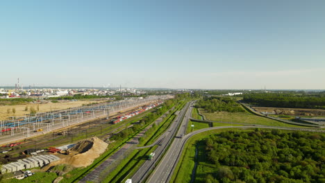 Antenne:-Fahrstraße-Neben-Grünem-Wald-Und-Güterbahnhof-In-Danzig,-Polen-An-Sonnigen-Tagen-Mit-Blauem-Himmel