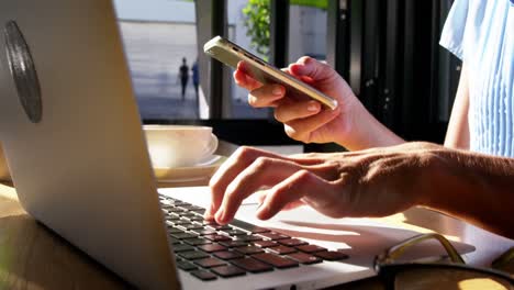 businesswoman using mobile phone and laptop