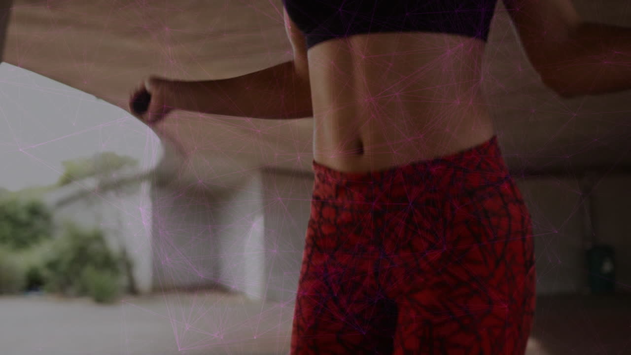 animación de conexiones sobre la sección media en forma mujer biracial haciendo ejercicio en la cuerda de salto