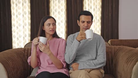 annoyed indian couple drinking tea and talking