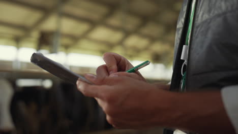 Manos-De-Primer-Plano-Escribiendo-Portapapeles-En-Las-Instalaciones-Agrícolas.-Administrador-De-Ganado-Hombre-Trabajo