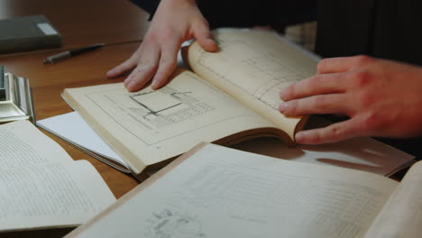 person reading an old technical manual at a desk