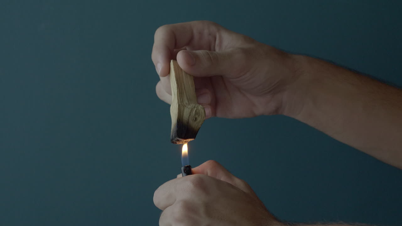 manos encendiendo un incienso de madera de palo santo. estático