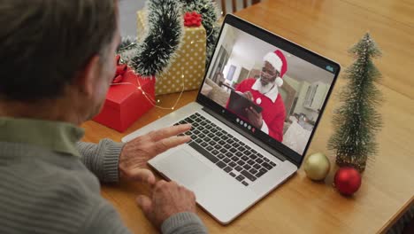 Caucasian-senior-man-on-video-call-with-santa-claus-at-christmas-time