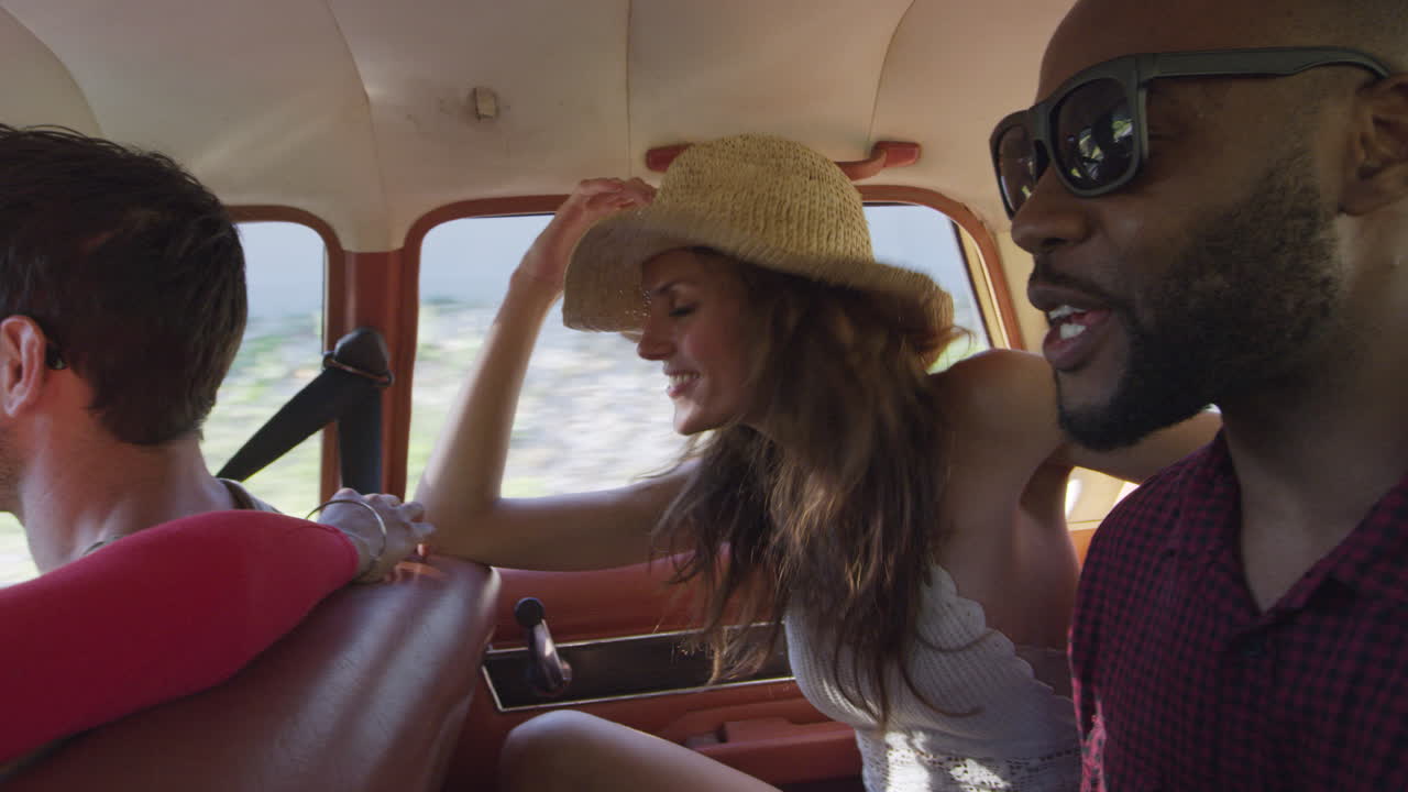Group Of Friends Sing In Back Seat Of Car During Road Trip