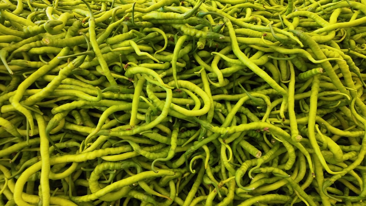 Pimentas Verdes Frescas Empilhadas em uma Banca de Mercado