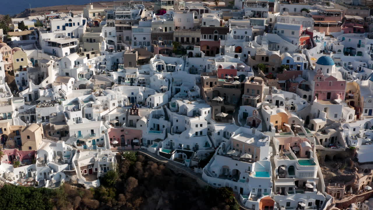 ciudad de oia con casas blancas y azules en santorini, grecia - toma aérea de drones