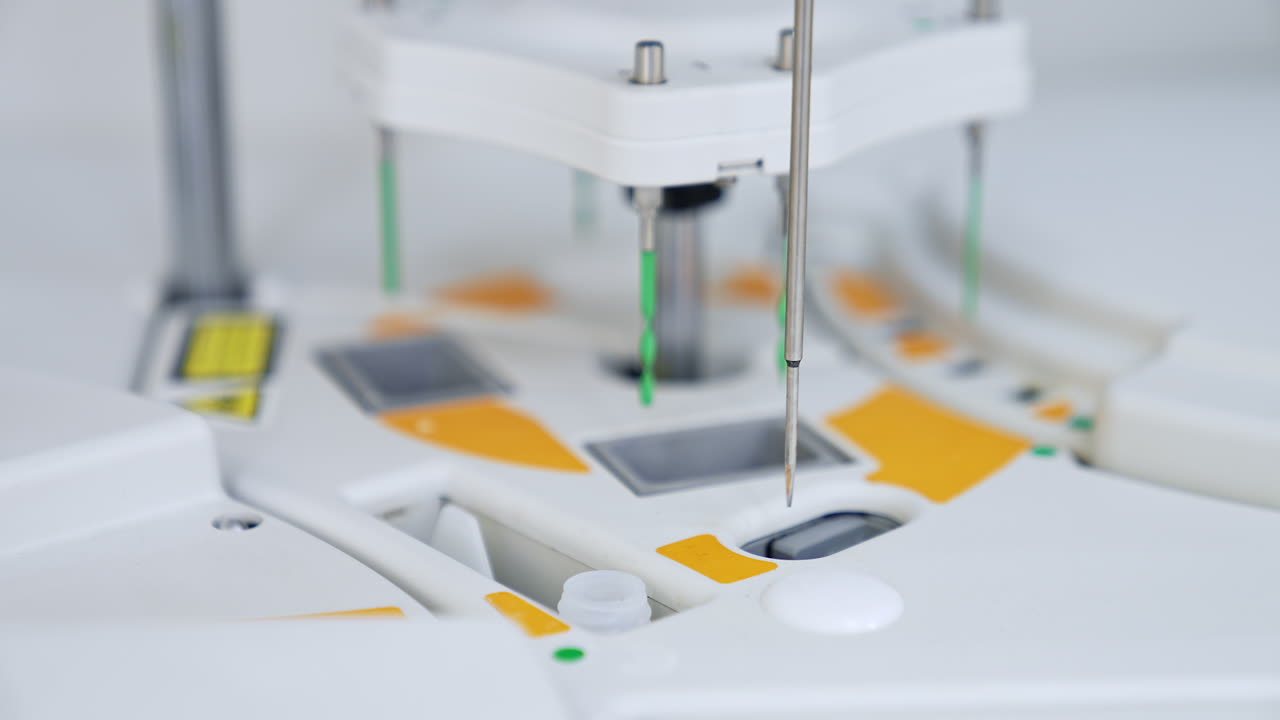 Metal needle lowering and deepening into the slots at machine. Close up. Advanced equipment carrying on medical testing. Blurred backdrop.