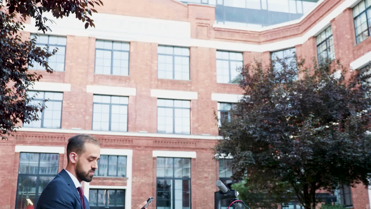 Businessman Using Phone with Scooter Outdoors