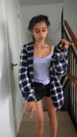 mujer bailando con camisa a cuadros y pantalones cortos
