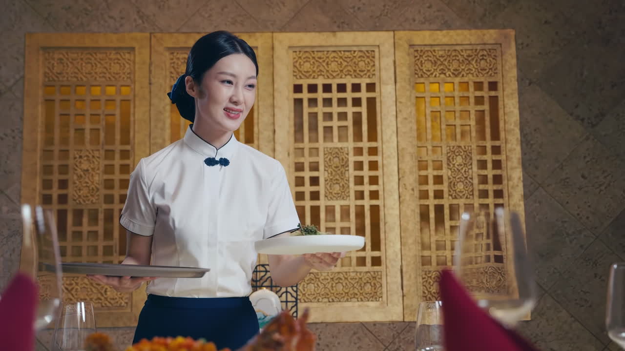 Professional Hotel waiter serving dishes, introducing them with a smile, holding a plate of food with a clear dome on top. introduce the hotel advertising to camera.