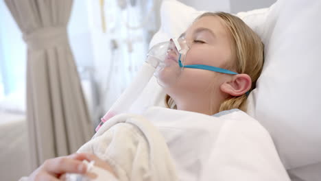 caucasian girl patient in oxygen mask asleep in hospital bed, slow motion