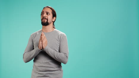 Portrait-of-man-putting-hands-together-in-praying-gesture,-waiting-for-results