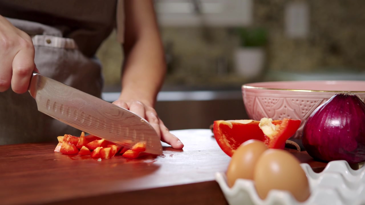 Donna prepara le verdure per fare una frittata.