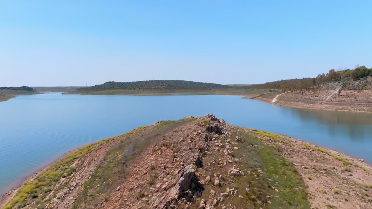 A rocky islet appears in a dam as water levels drop during summer.
