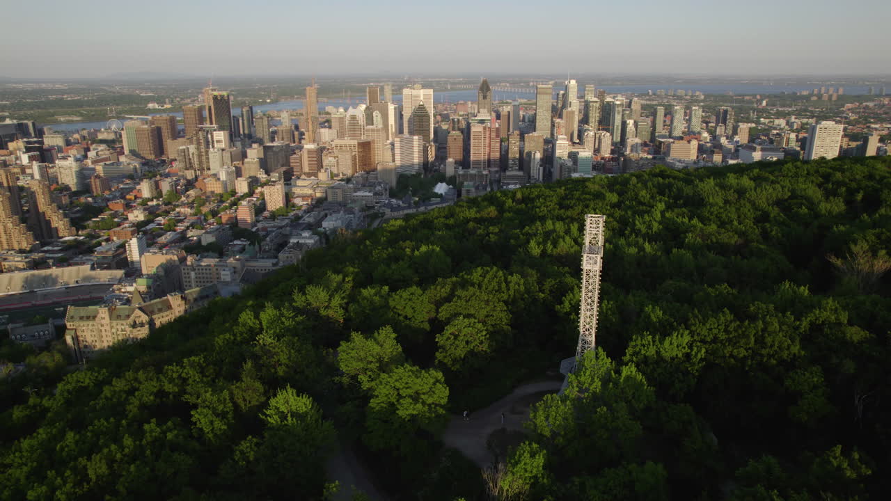 몬트리올 스카이라인을 배경으로 마운트 로 ⁇  꼭대기에 있는 십자가 주위의 공중 전망