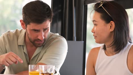 happy male and female friends toasting soft drink glasses at cafe