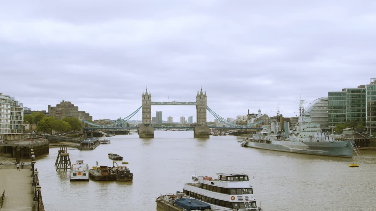London Bridge landmark and HMS Belfast in the Thames in central London against a cloudy sky