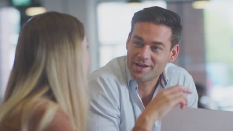 close up of business team having meeting sitting around table in modern open plan office