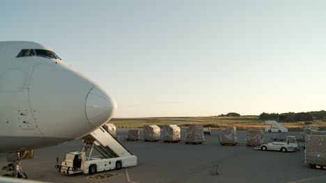 esta imagen muestra un gran avión blanco boeing 747, caracterizado por su nariz puntiaguda y una extensa ventana de la cabina, estacionado en una pista