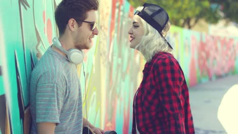 Trendy-young-couple-chatting-in-an-urban-street