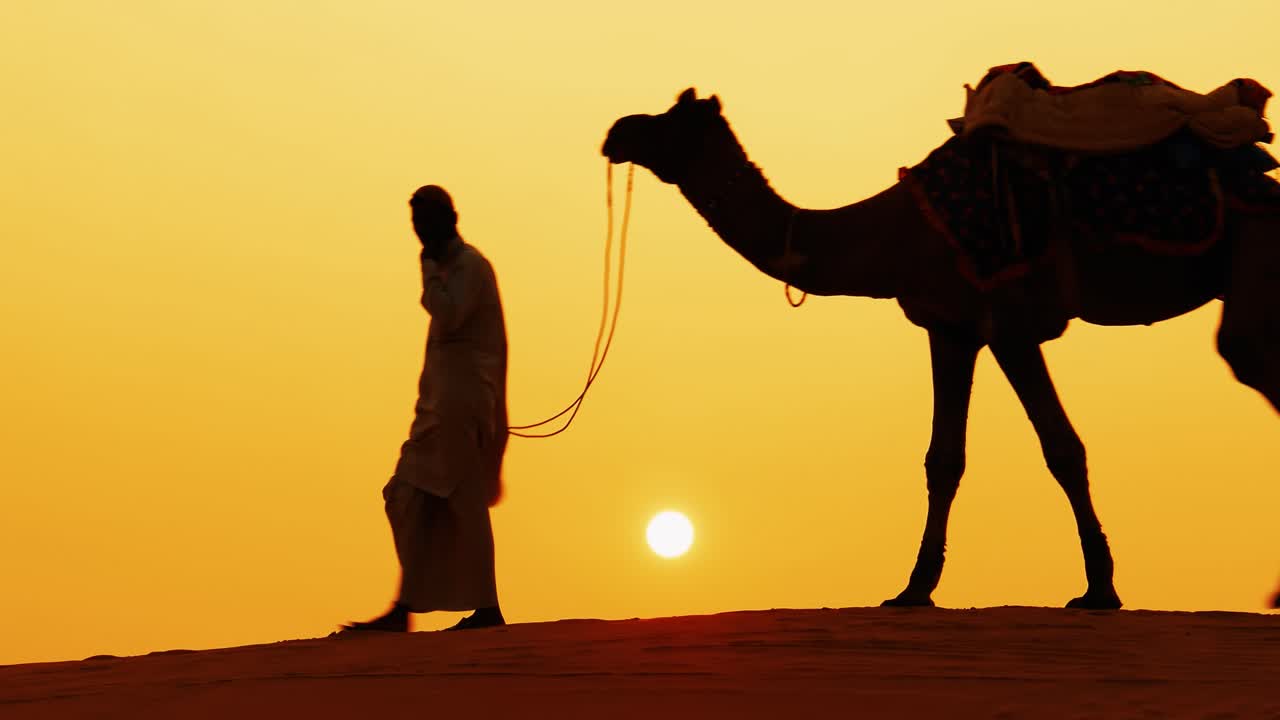 Camerieri, cammellieri al tramonto. Deserto di Thar sul tramonto Jaisalmer, Rajasthan, India.