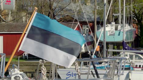 The waving Estonia flag on the small pole on the sailboat