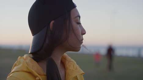 close up portrait young teenage girl looking pensive enjoying calm day sunset in seaside park wind blowing hair slow motion