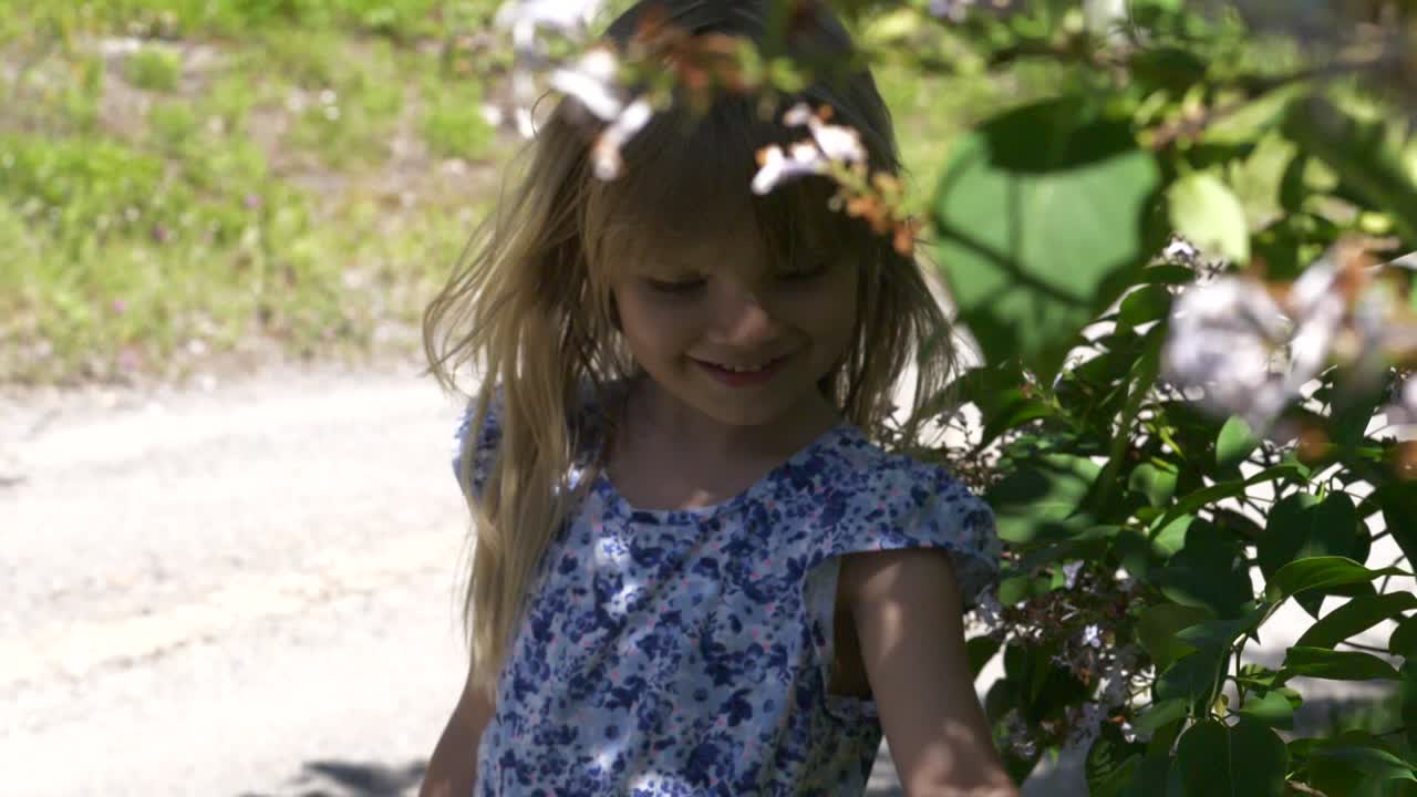 chica de pie a la sombra de algunas flores en un día de verano