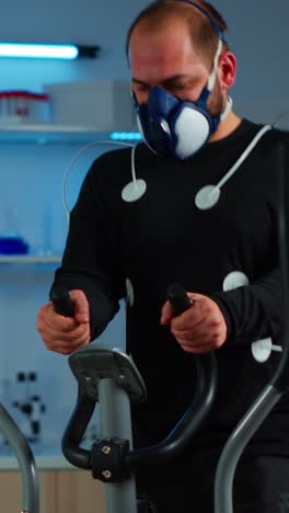 man undergoing medical exercise test in laboratory with respiratory mask and electrodes