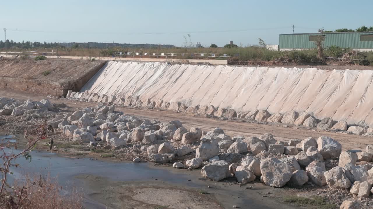 Construction site with rocks and a protective barrier