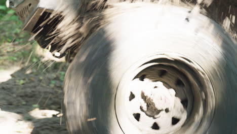 off-road vehicle wheels moving forward in muddy terrain. close up