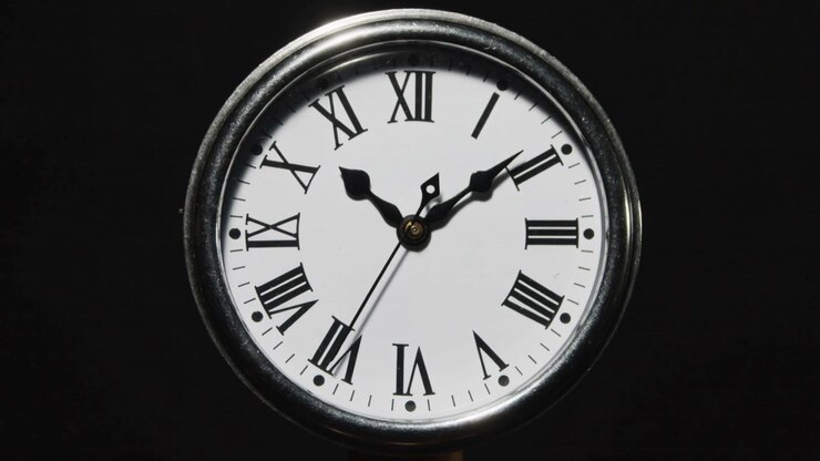 Advancing second hand shifting minute and hour hands indicating time in studio, with metal bezel