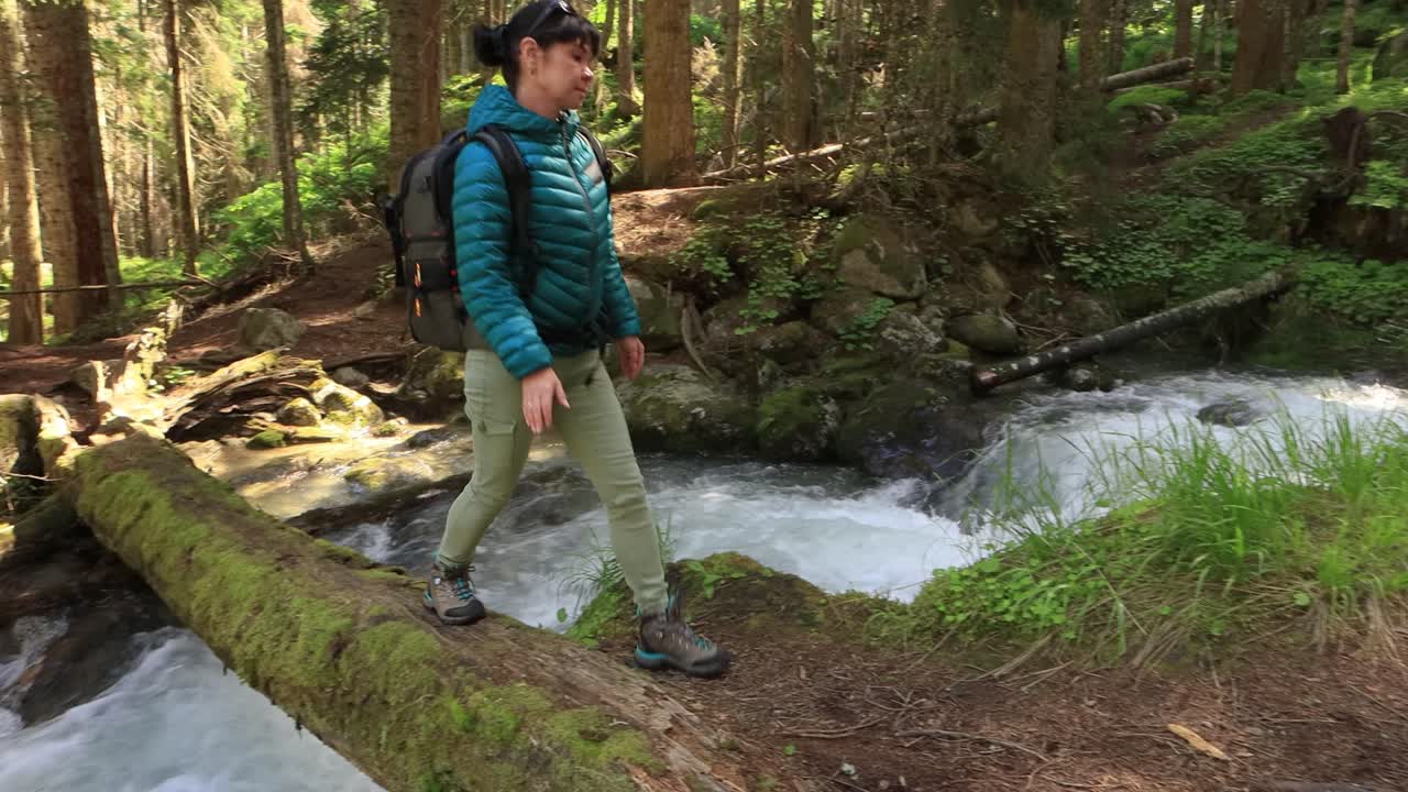 하이킹 여자 는 봄 의 녹색 숲 에서 하이킹 배 ⁇  을 들고  ⁇ 다