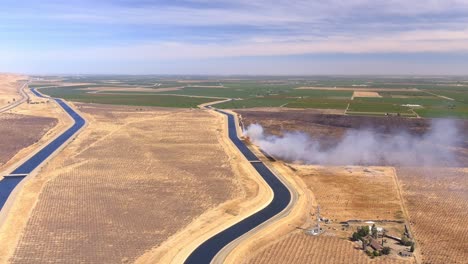 humo de incendios forestales procedente de las extensas tierras bajas del valle central cerca de su campo de cultivo en california, ee.uu.