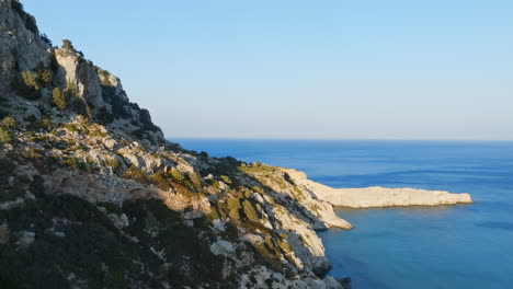 aerial view flying along the rocky coastline of rhodes, sunny evening in greece