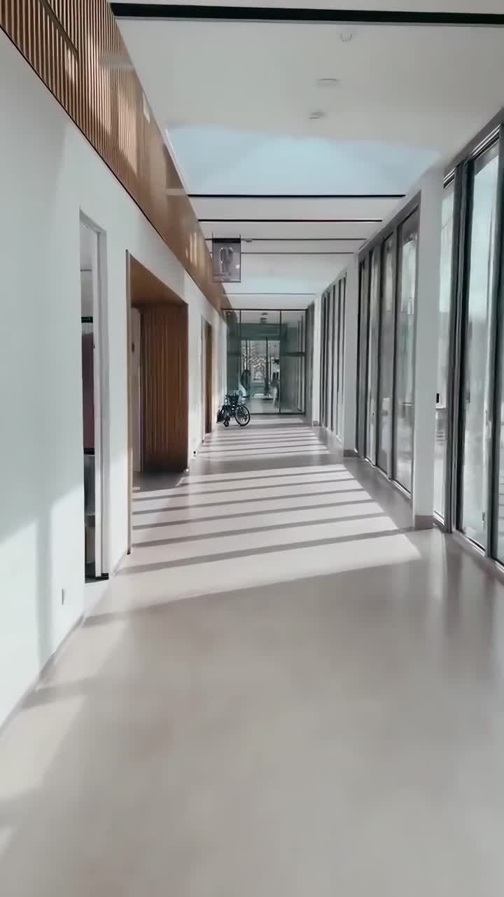 Pasillo moderno con luz natural y sombras, capturado en un video de gran angular.