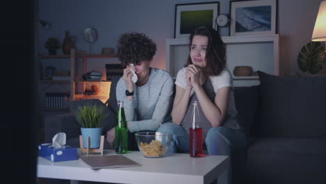 two women watching a sad movie or sport game