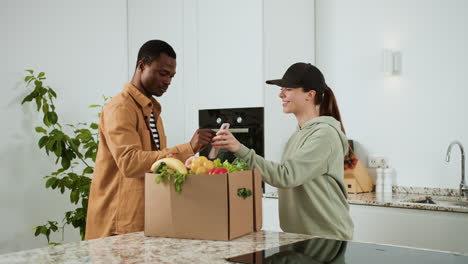 man receiving box of vegetables