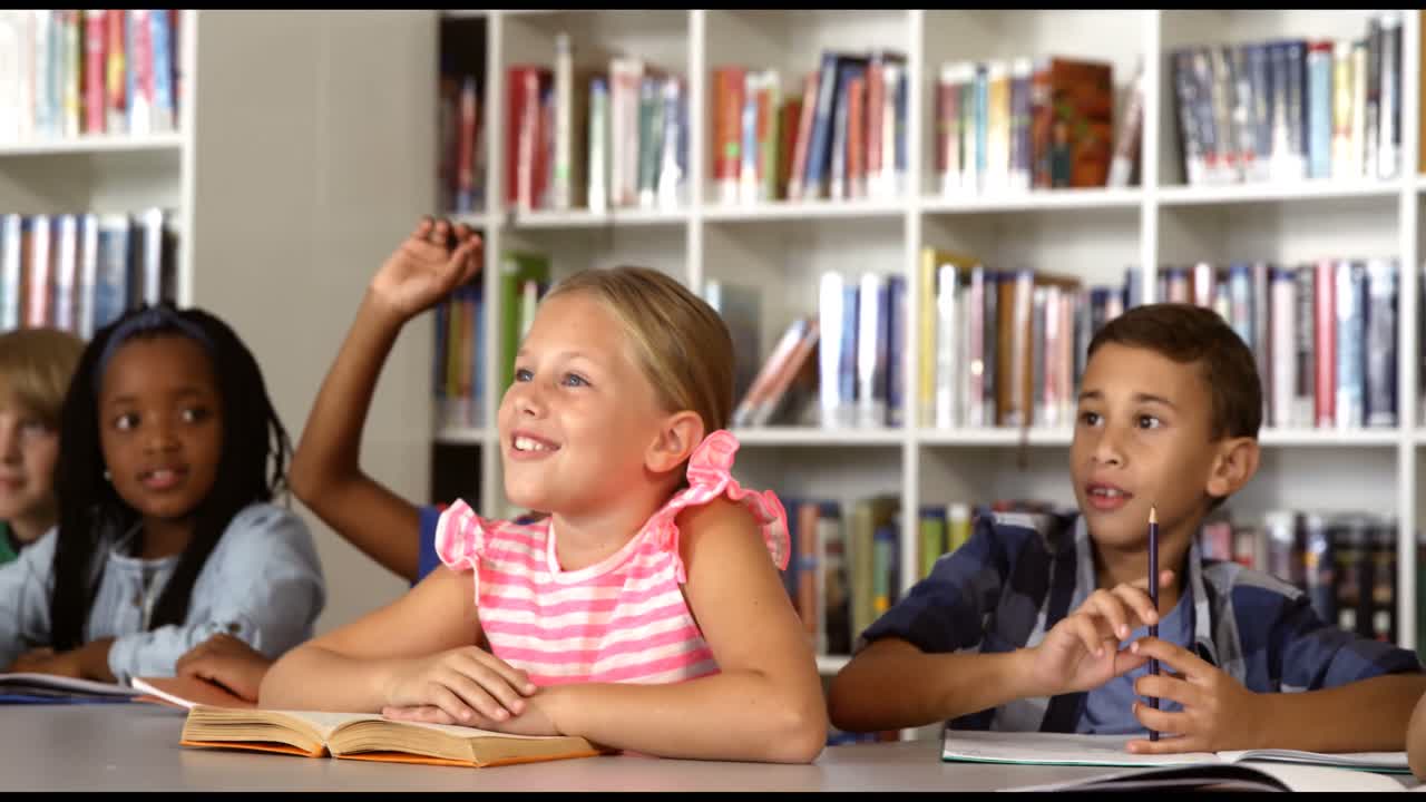 School kids raising hand in library