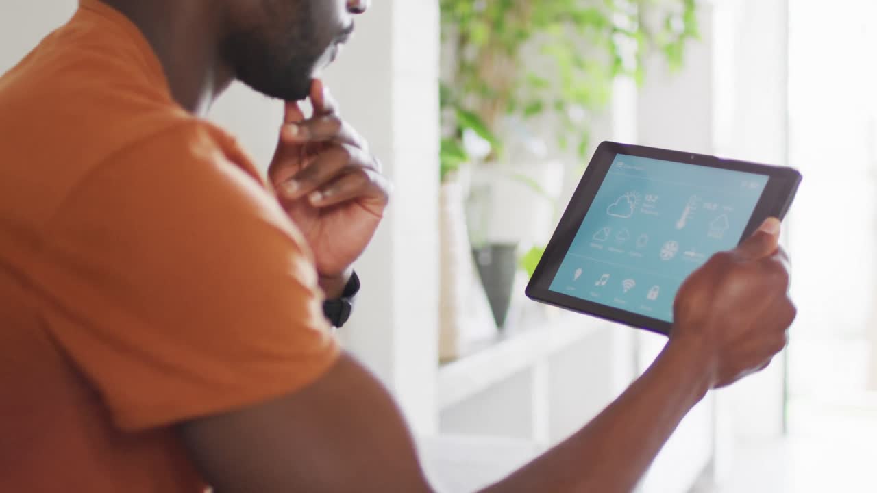 Happy african american man using tablet with weather forecast