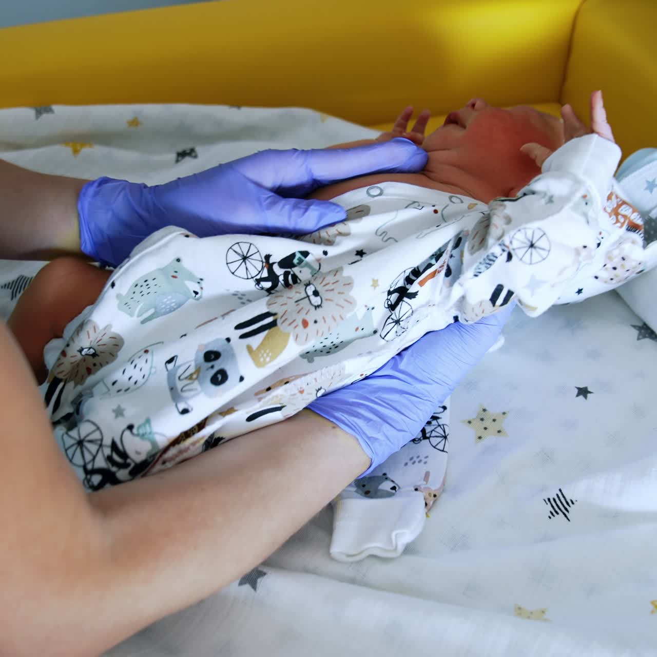 Medic's hands in gloves dressing the cute baby. Little child is unhappy and starts to cry. Close up