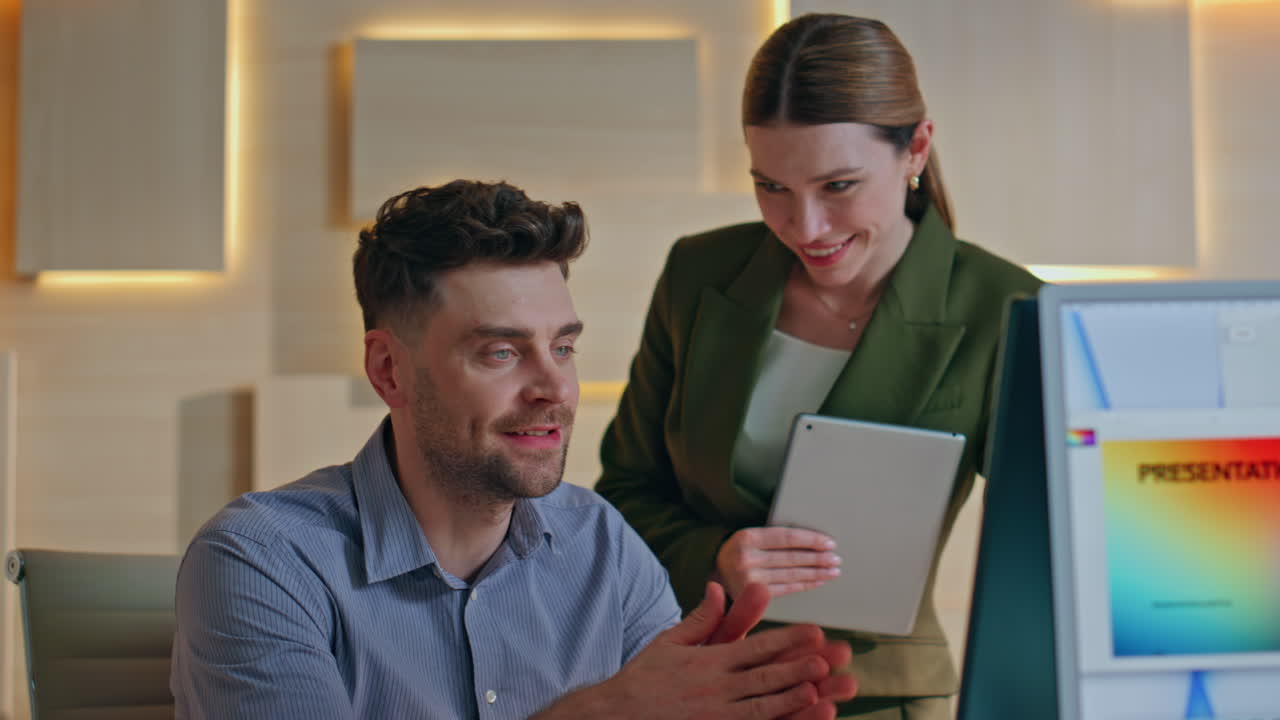 Happy two colleagues videocalling by computer in contemporary office close up.